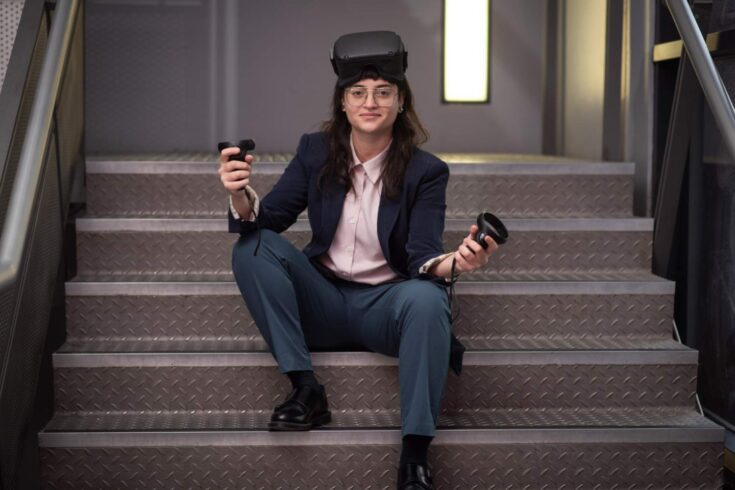 Eve Gregoriou sitting, holding her virtual reality technology handset