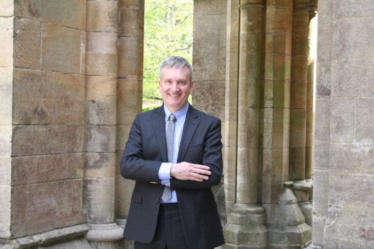 Professor Guy Poppy standing with his arms crossed, smiling.