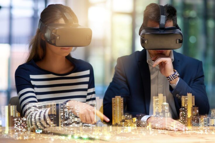 Two business people wearing virtual reality headset superimposed over a cityscape