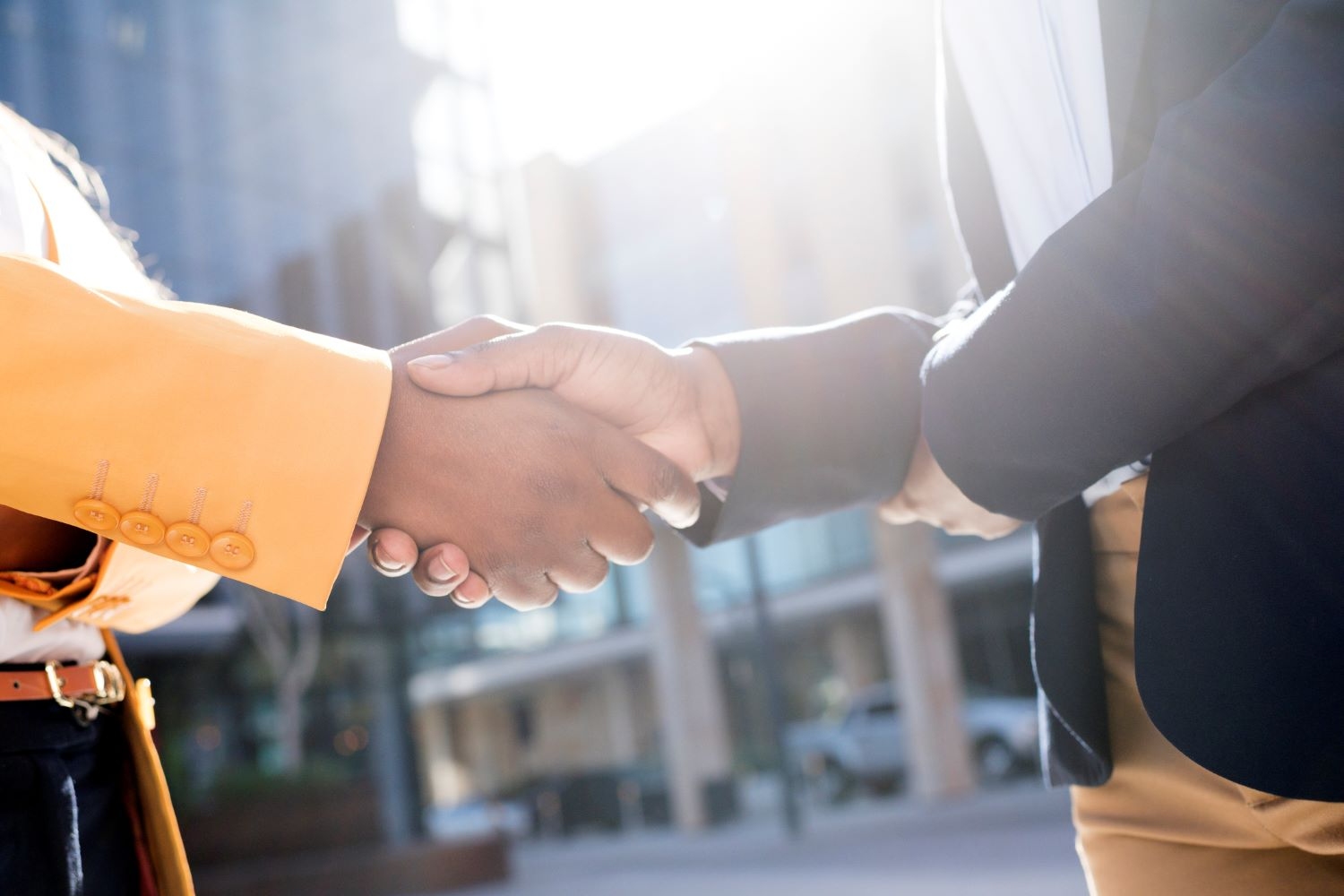 Close up photo of woman handshake outside glass building