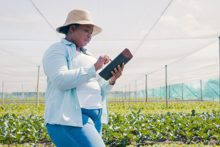 Shot of a young woman using a digital tablet while working on a farm