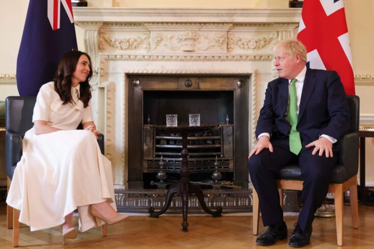 Jacinda Ardern (New Zealand Prime Minister) and Boris Johnson (UK Prime Minister) sitting and looking at each other.