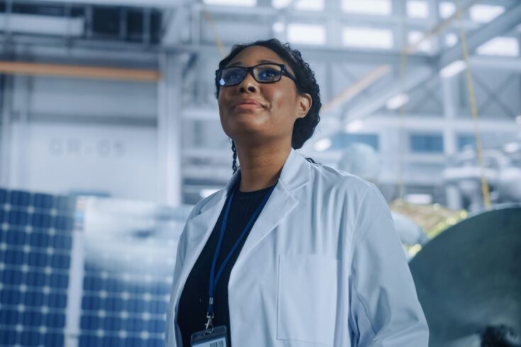 Female engineer looking around in wonder at the Aerospace Satellite Manufacturing Facility