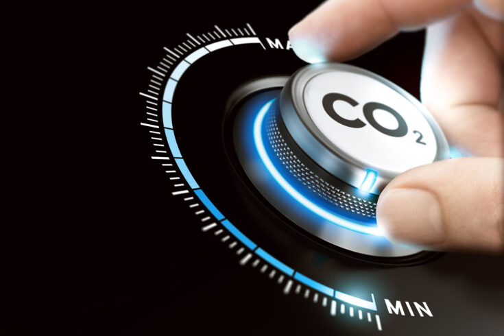 Man turning a carbon dioxide knob to reduce emissions. CO2 reduction concept.