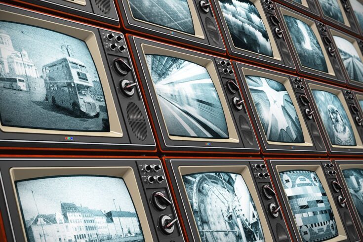Bank of old TV sets showing black and white footage