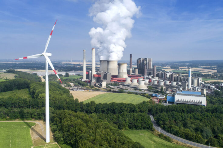 Aerial view of a wind turbine and coal power station.