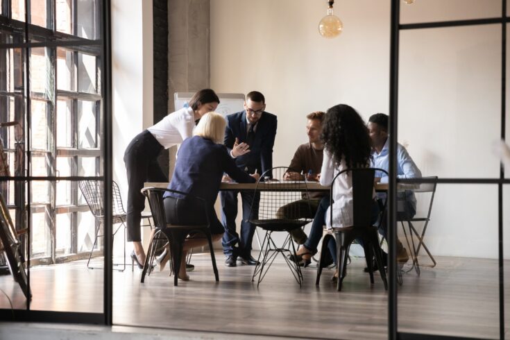 Diverse employees team engaged in teamwork in modern boardroom