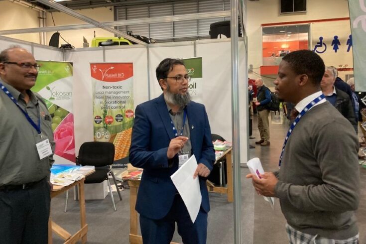 Paul Laniran talking to two men on a stand at the Fruit Focus farming event