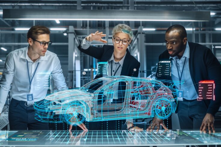 A diverse team of engineers looking at an electric car augmented reality hologram