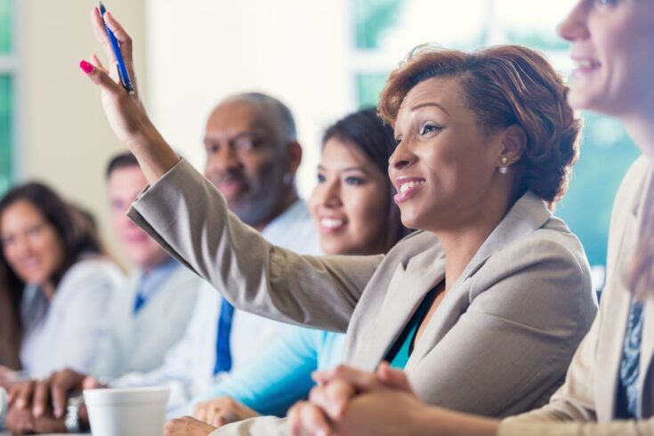 African American businesswoman raising hand, asking question in business conference