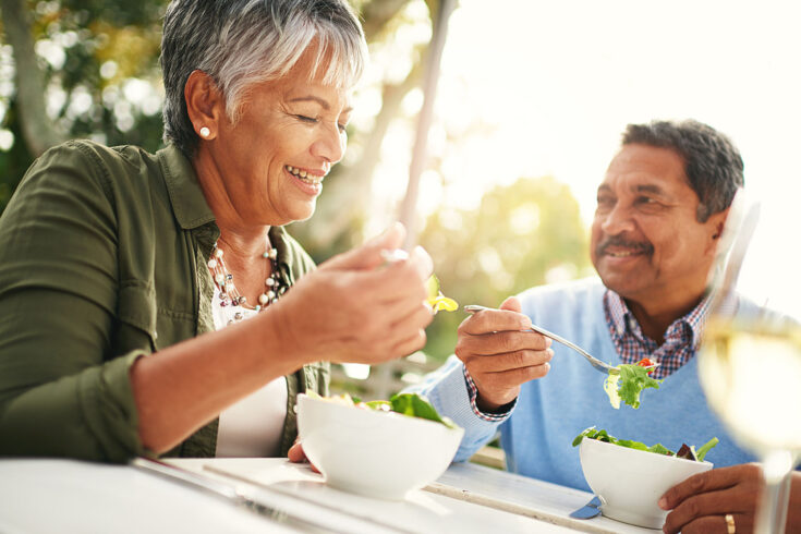 Shot of a happy older couple enjoying a healthy lunch together outdoors.