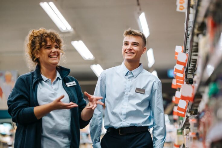 Supermarket manager training young employee