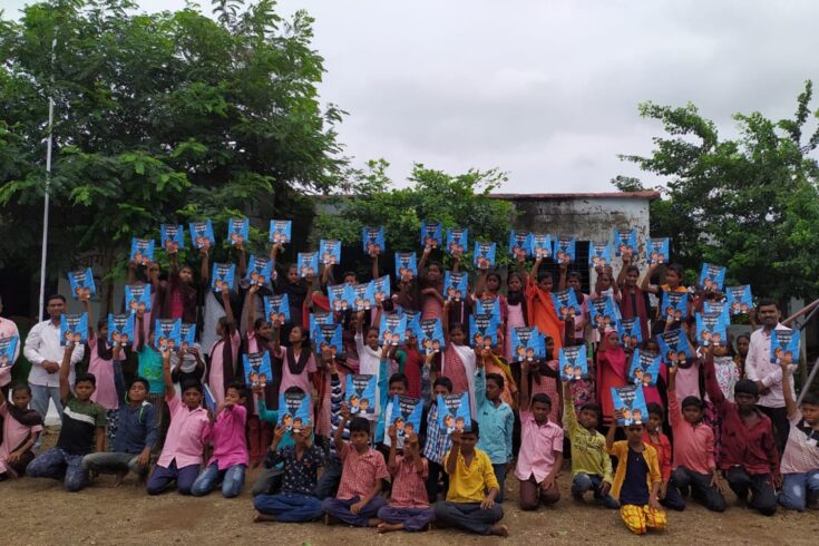 Group of children holding up their Listen to the Universe books