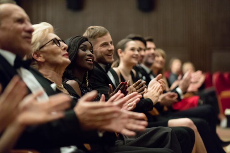 Side view of audience clapping hands