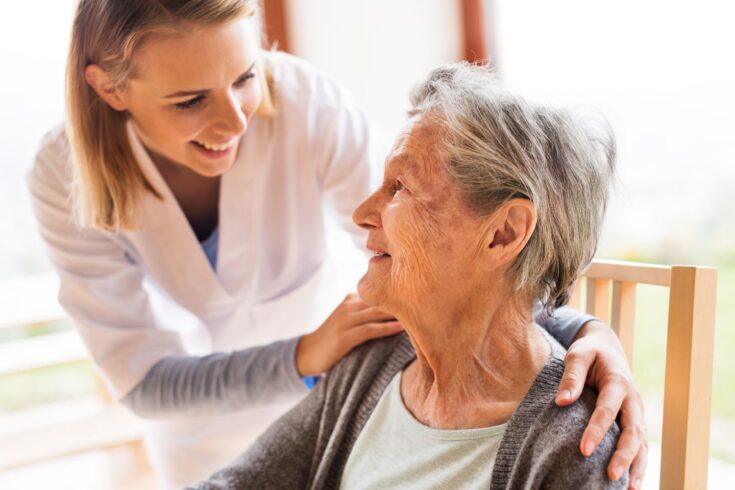 A nurse talking to an elderly woman.