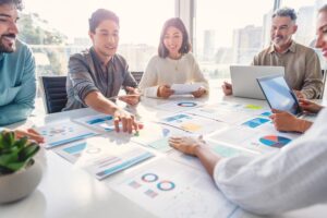 Group of people working with paperwork on a board room table