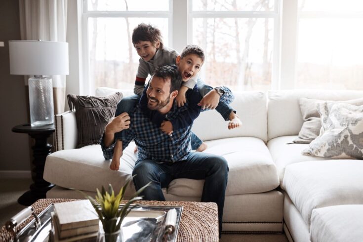 Shot of two adorable little boys having fun with their father at home