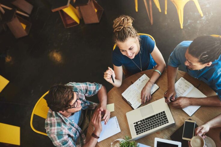 High angle shot of a group of students studying in a coffee shop