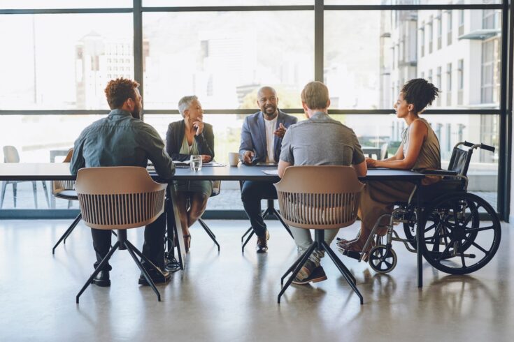 A diverse group of men and women talking around a table