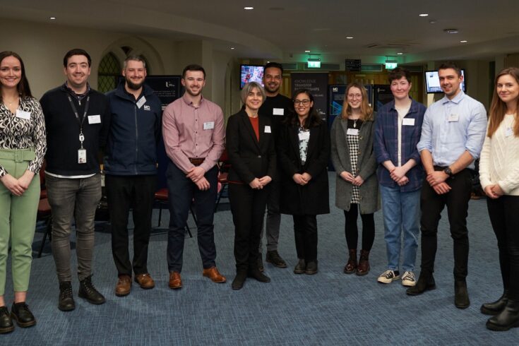 10 people stood in an arched line wearing name tags