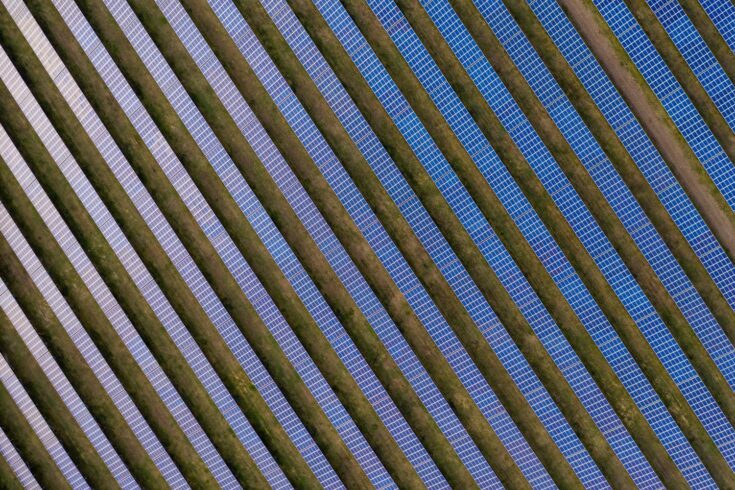 Aerial view of a field with rows of solar panels