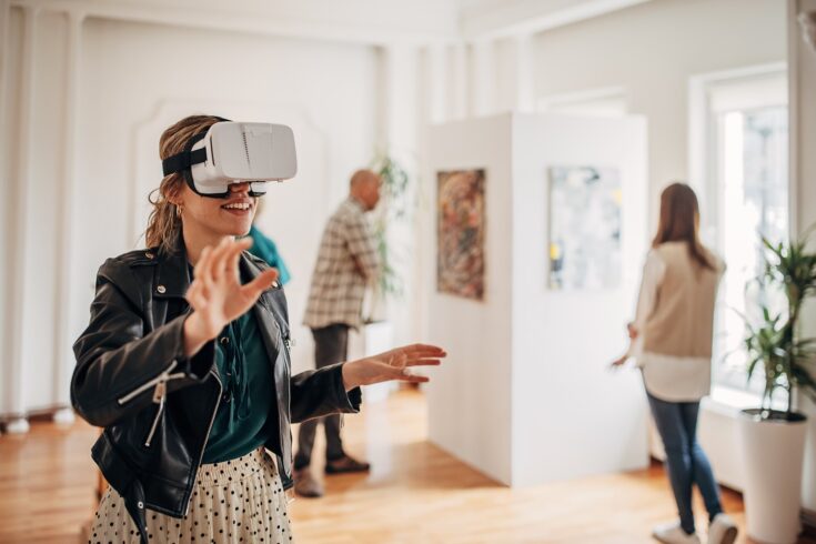 oman wearing VR gear while enjoying experience at modern art gallery exhibition.