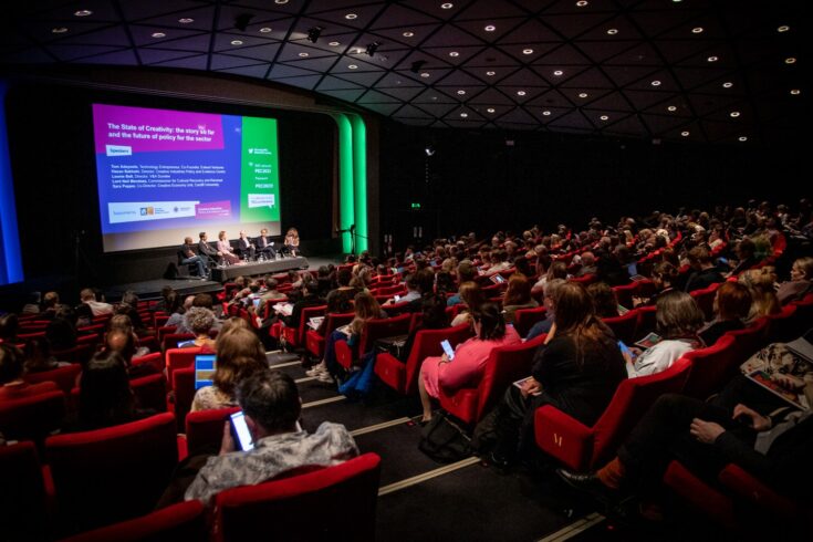 State of Creativity conference showing audience listening to a panel of speakers on the stage