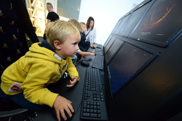 Young children looking at science-related activities on computer screens at Daresbury Laboratory Open Day.
