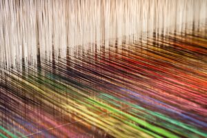 Close-up of a loom weaving colourful fabric