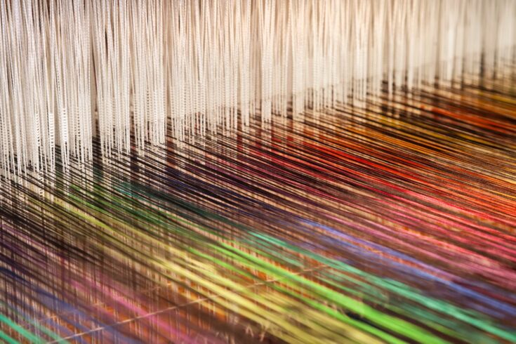 Close-up of a loom weaving colourful fabric