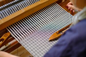 Someone using an old fashioned loom