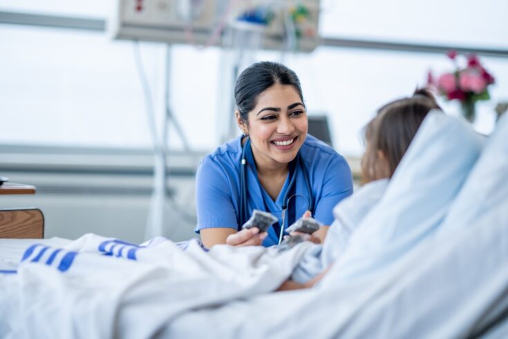 Doctor talks to patient in hospital bed