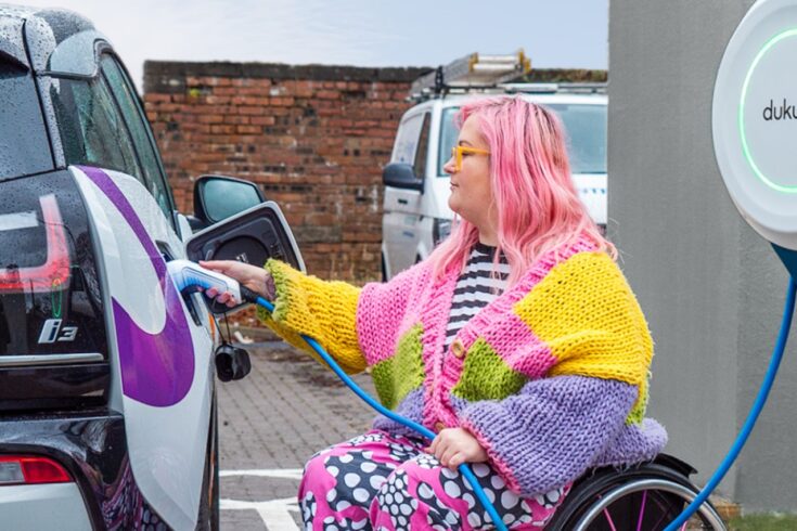 Wheelchair user charging their electric car