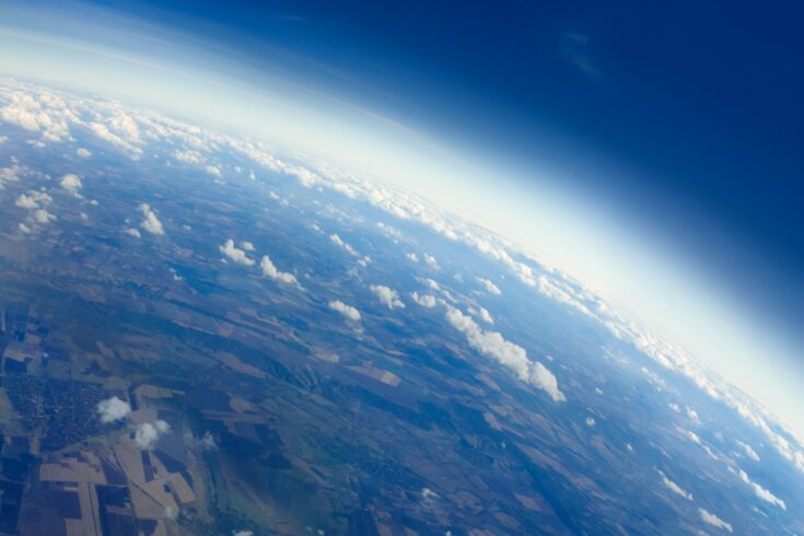 Aerial view of planet Earth from the stratosphere above 30000 feet, with clouds, the horizon and a little bit of space.