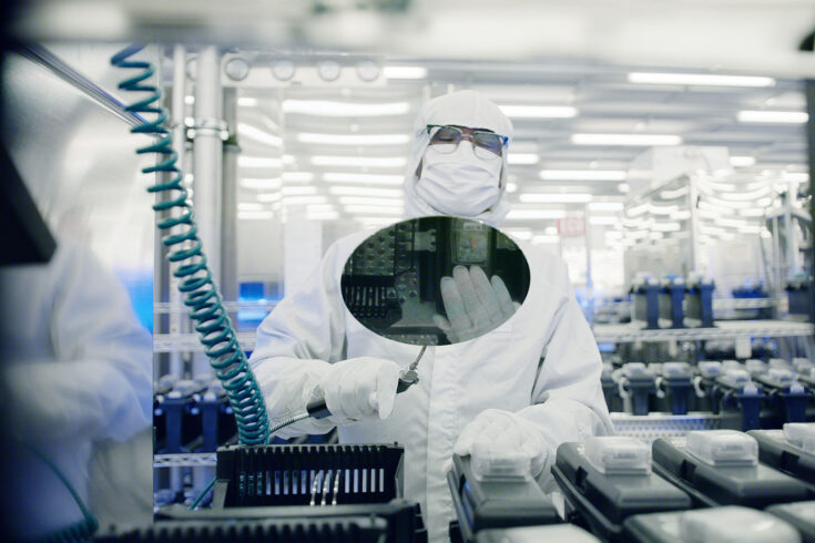 A researcher holding a reflective disc.