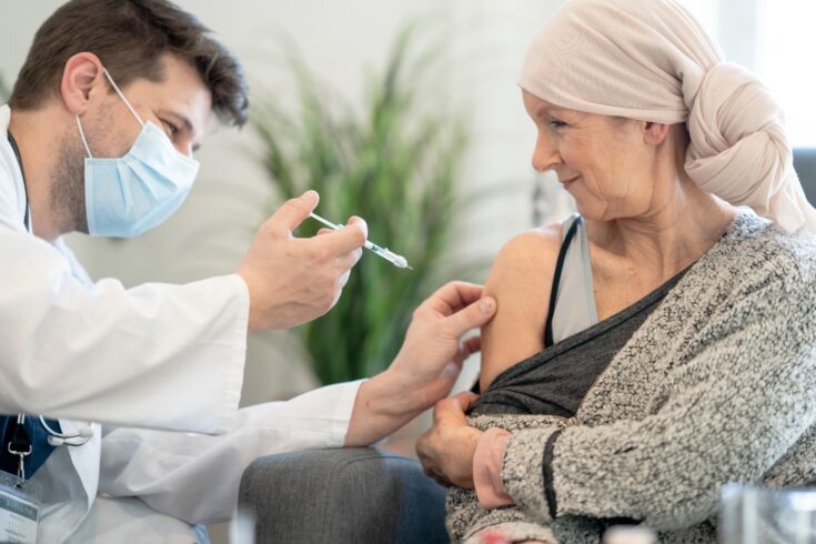 Doctor giving cancer patient a vaccination