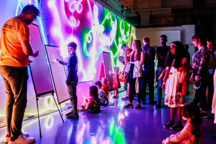 Visitors of all ages viewing a science exhibit at Daresbury Open Week.