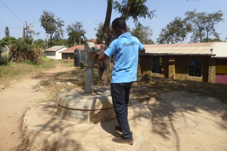 FundiFix mechanic inspecting a non-functioning handpump.