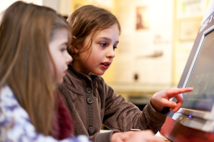 Two children using an interactive screen