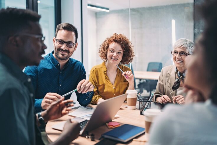 Multiracial group of business people sitting around a table and talking