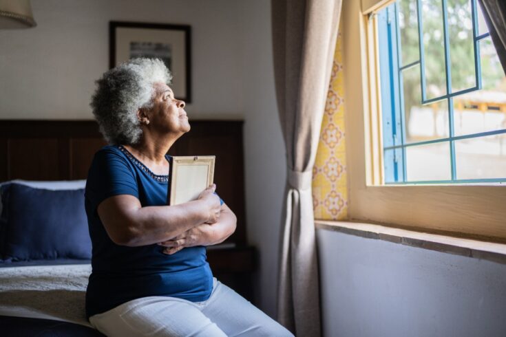 A bereaved woman looking out of a window