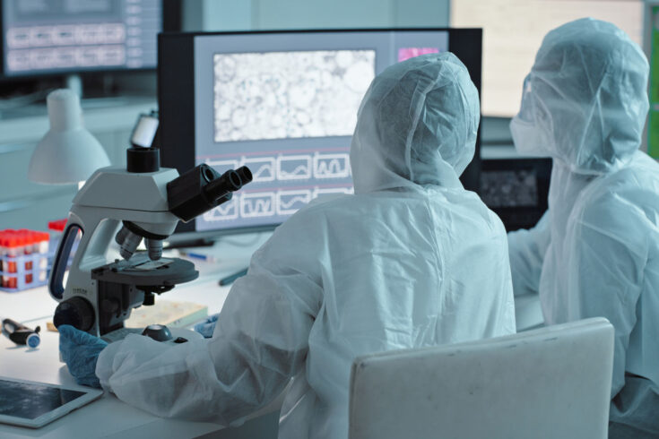 Collaboration, science and computer with a doctor women team in a laboratory for COVID research in PPE uniform. Teamwork, innovation and experiment with scientist females working together in a lab.