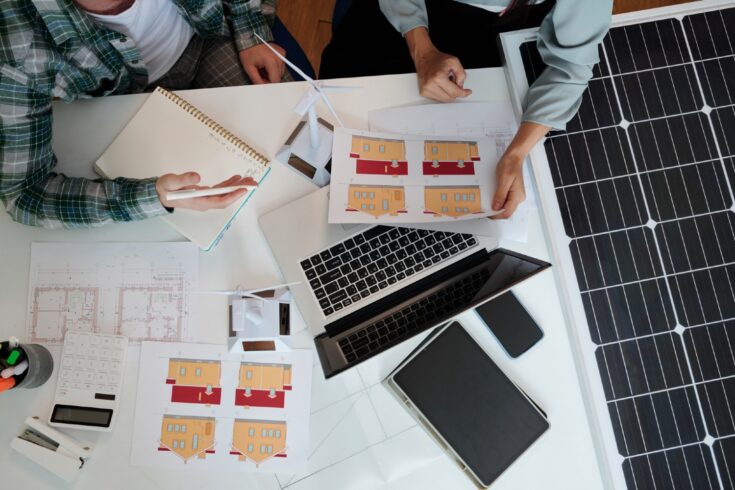 Close up of people working on a solar energy project at a desk