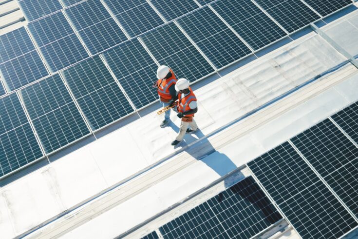 Men walking on roof with solar panels