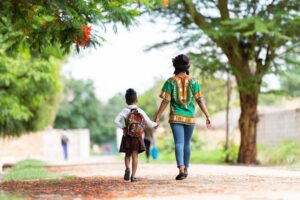 A mother walking her daughter to school on a rural road