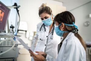 Two female doctors discussing some exams together at the hospital.