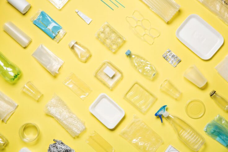 Yellow background with plastic bottles and packaging laid down on it.