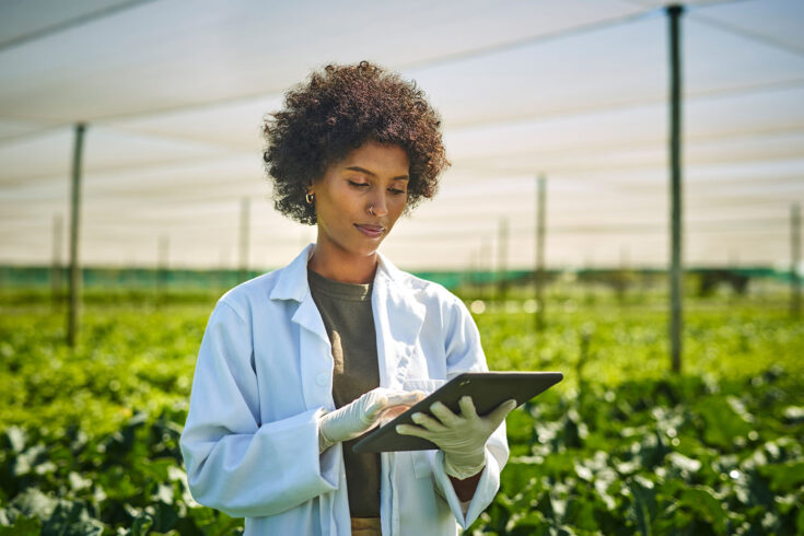 Shot of a young scientist using a digital tablet while working with crops on a farm. Showing that not all research is done in a lab.