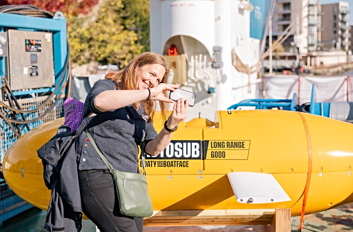 Woman taking a picture of herself in front of an autosub vehicle.