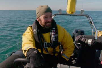 John ‘Mac’ McDonald sat on a boat on the ocean